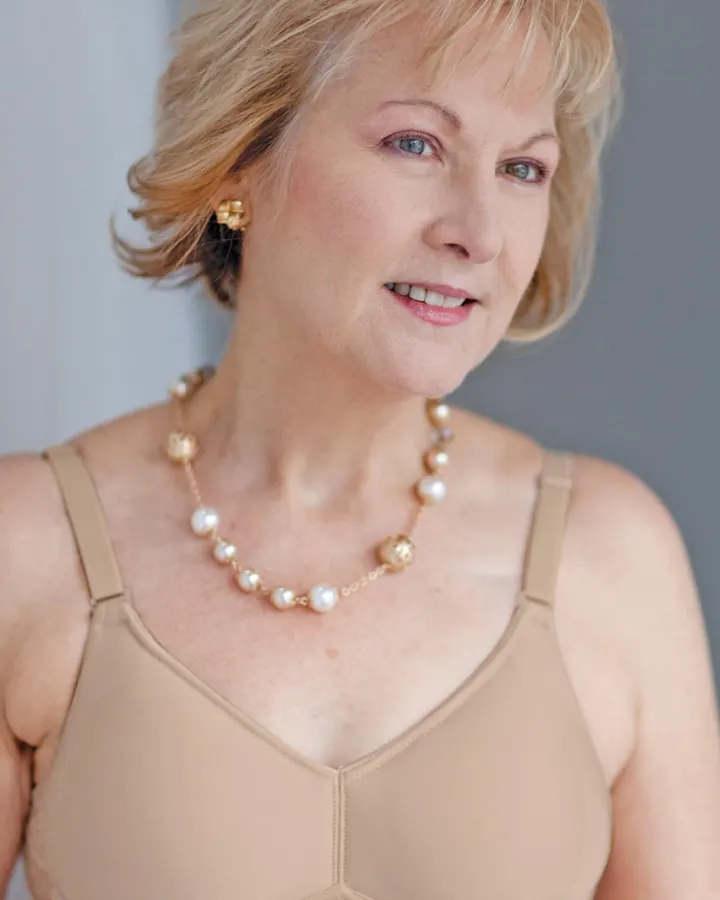 Manon en soutien-gorge chair et collier de perles