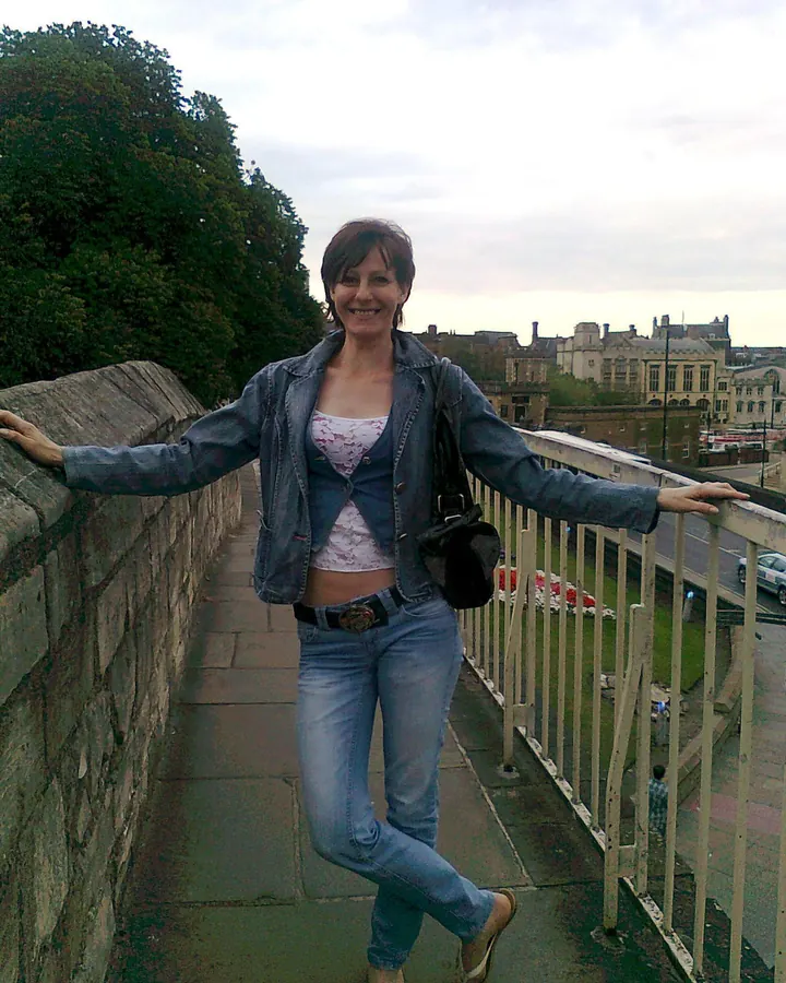 Femme en haut vert, souriante, regard baissé
