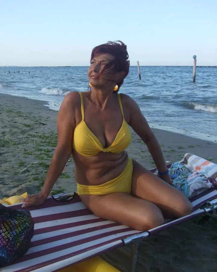 Femme en haut vert, souriante, regard baissé